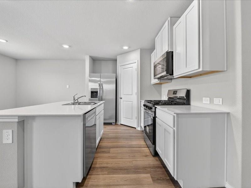 5568 Corduroy Road Krum, TX 76249 - Photo 7 of 23 a kitchen with stainless steel appliances granite countertop a sink and cabinets