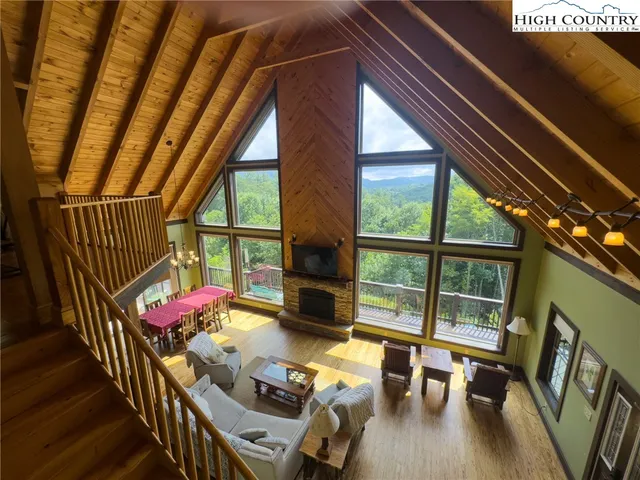 a living room with furniture floor to ceiling window and wooden floor