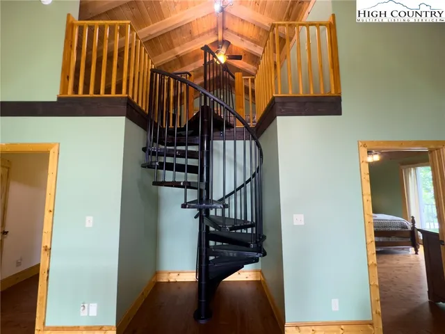 a view of hallway with stairs and wooden floor