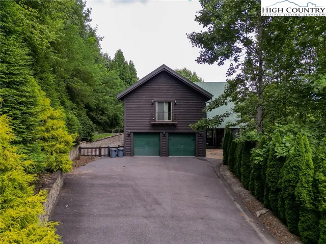 a view of a house with a yard and large trees