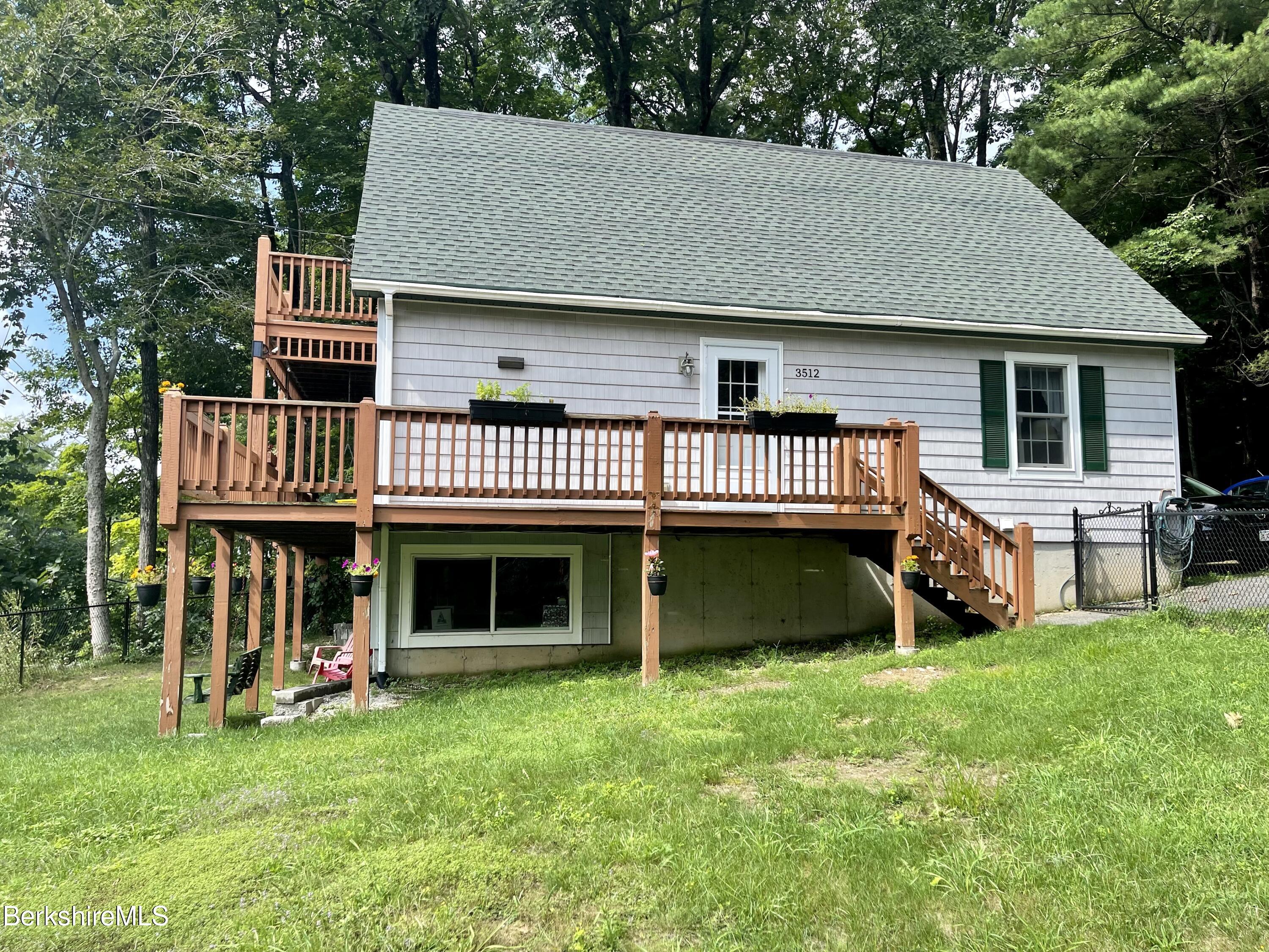 3512 Jacobs Ladder Road Becket, MA 01223 - Photo 1 of 42 a front view of a house with a garden and deck