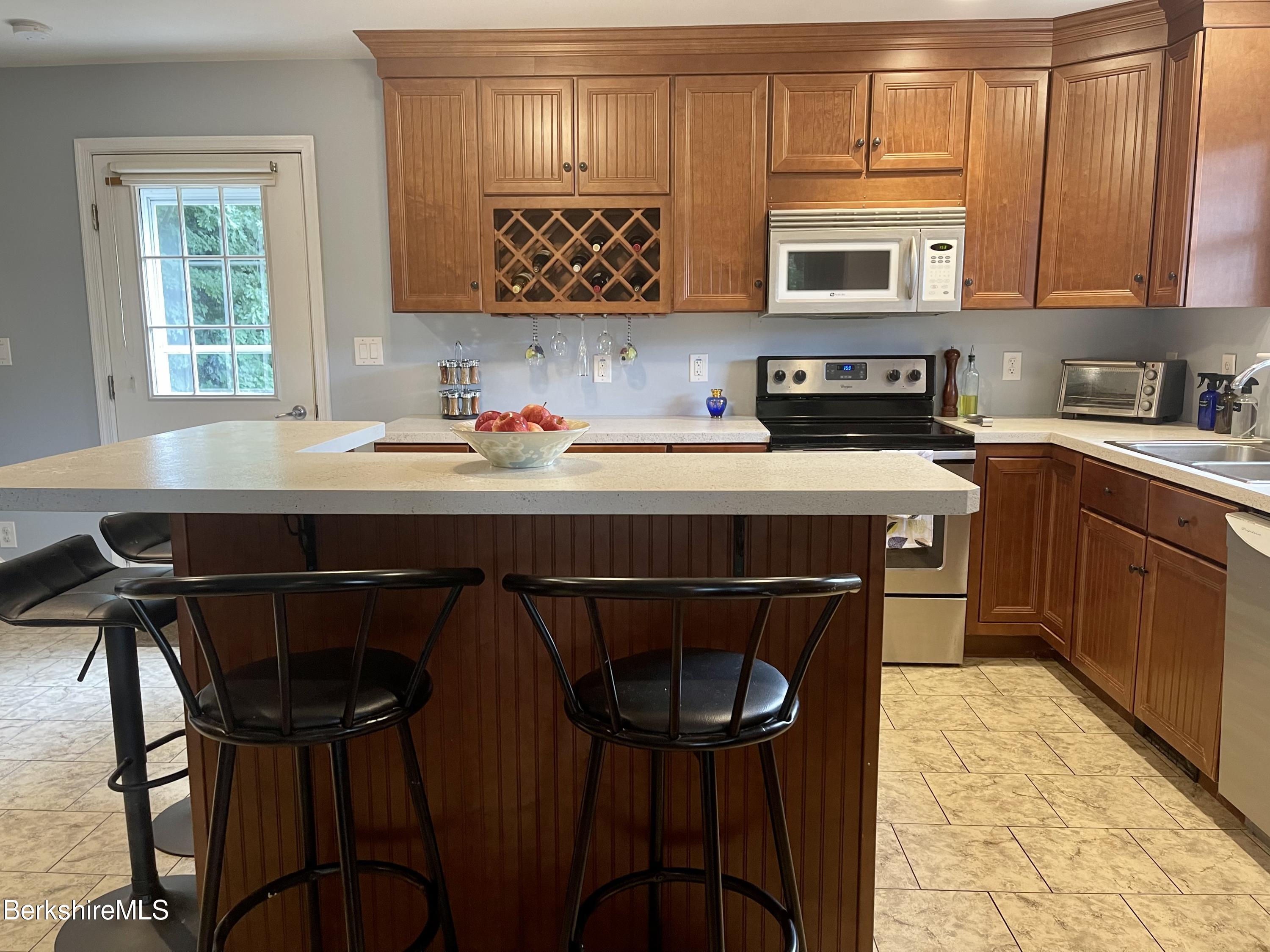 3512 Jacobs Ladder Road Becket, MA 01223 - Photo 7 of 42 a kitchen with stainless steel appliances a stove a sink cabinets and a dining table