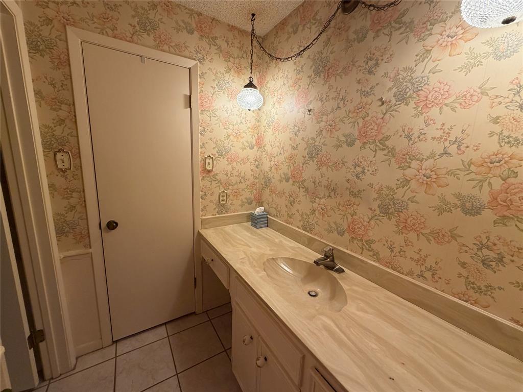 1218 Nottingham Road Abilene, TX 79602 - Photo 18 of 22 a bathroom with a granite countertop sink a shower and a mirror