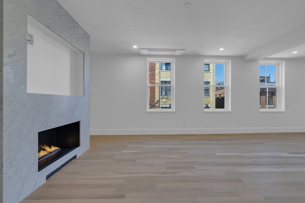 a view of an empty room with window and fireplace