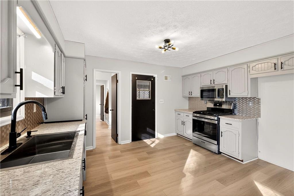 752 Maple Drive Riverdale, GA 30274 - Photo 9 of 35 a view of living room kitchen with stainless steel appliances cabinets and living room