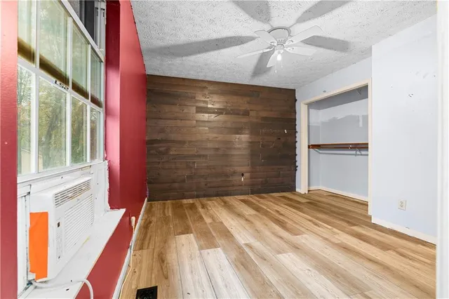 a view of empty room with window and ceiling fan