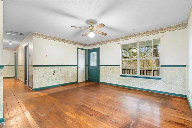 a view of a livingroom with a ceiling fan and window