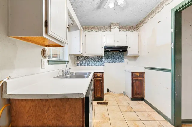 a kitchen with a sink a refrigerator and cabinets