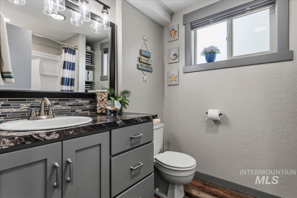 6323 Foothill Road Star, ID 83669 - Photo 27 of 50 Bathroom featuring a gray vanity with a dark patterned countertop, tile backsplash, and a polished chrome faucet
