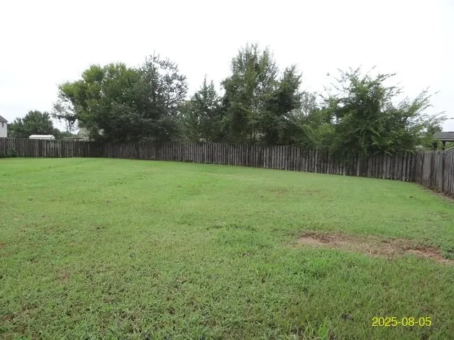 a view of a field of grass and trees