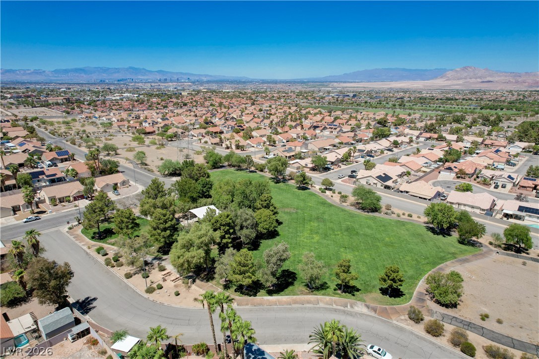 811 Rio Poco Court Henderson, NV 89015 - Photo 40 of 42 An aerial perspective reveals a vibrant neighborhood with a verdant park, encircled by residences and distant mountains.