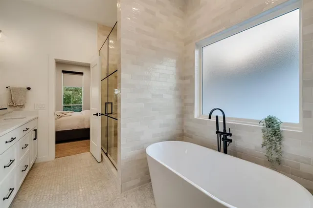 a bathroom with a tub sink and mirror