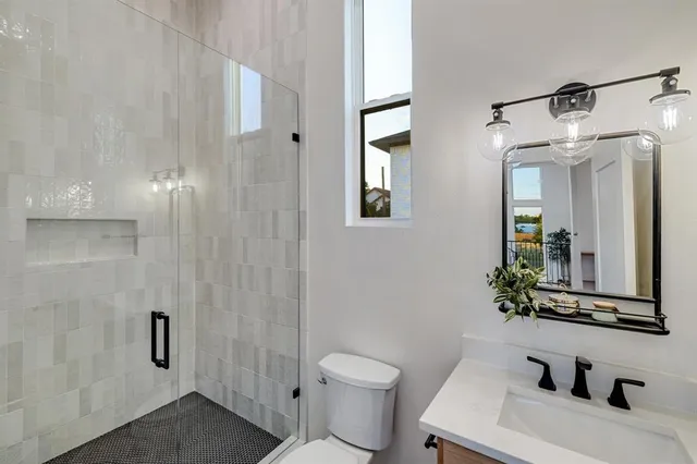 a bathroom with a granite countertop sink toilet and shower