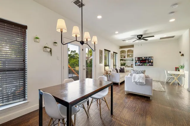 a living room with furniture kitchen view and a wooden floor