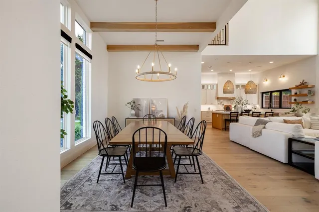 a view of a dining room with furniture a chandelier and a window