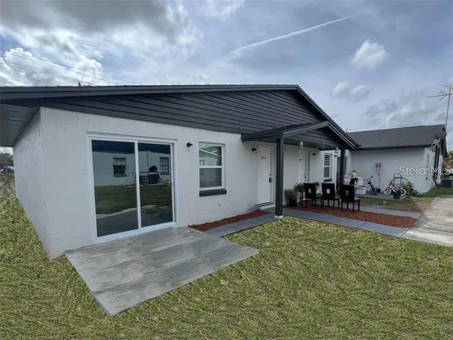 a view of a house with yard and sitting area