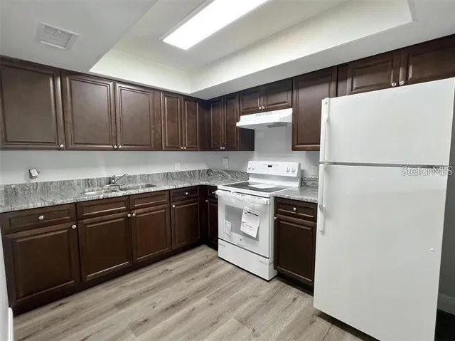 a kitchen with a refrigerator sink and cabinets