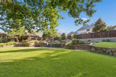 a view of a chair and table in backyard of the house