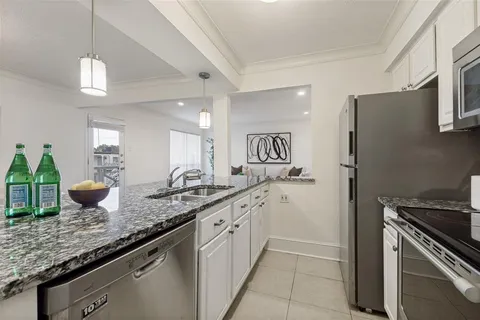a kitchen with granite countertop a sink appliances and cabinets