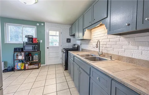 a kitchen that has a sink and a stove in it