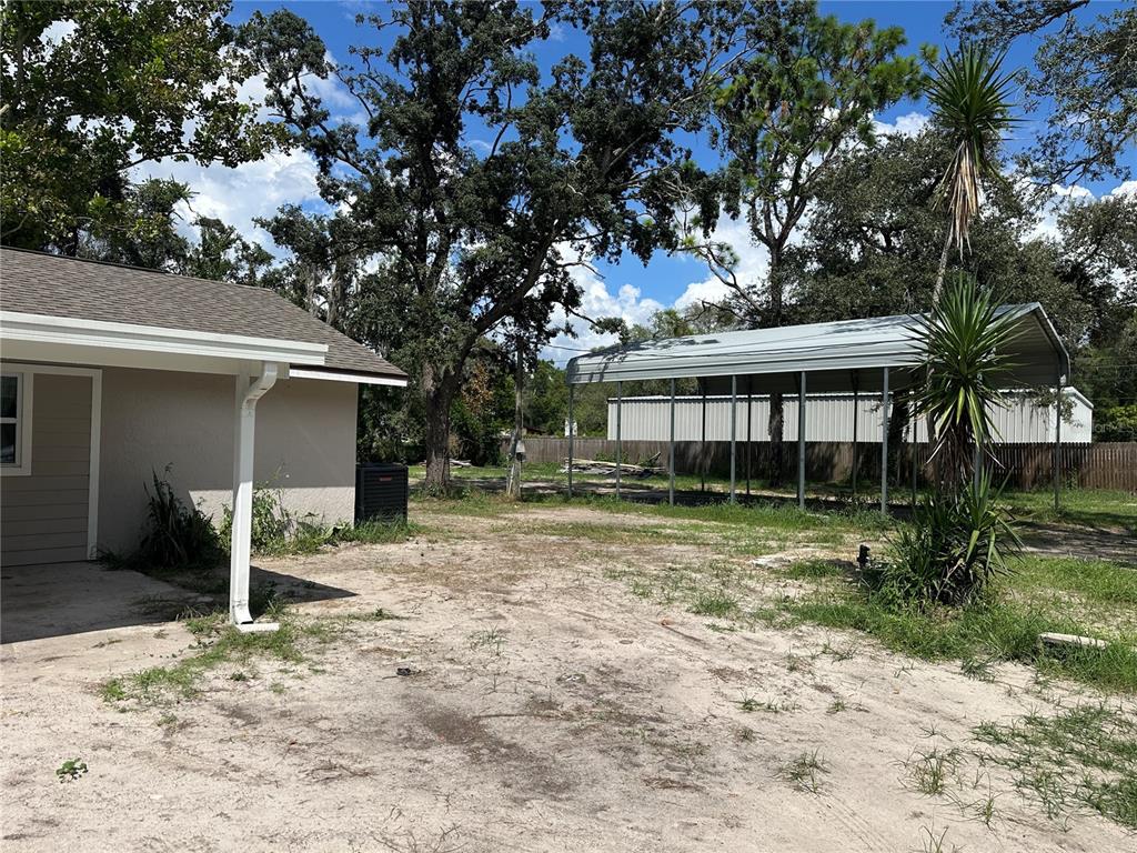a view of a house with a yard and large tree