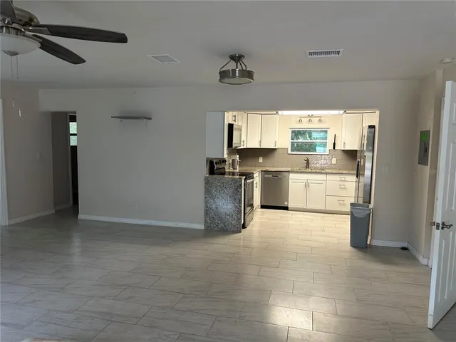 a large kitchen with stainless steel appliances a stove a refrigerator and a sink