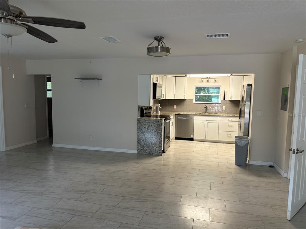15921 Breakwater Lane Spring Hill, FL 34610 - Photo 11 of 26 a large kitchen with stainless steel appliances a stove a refrigerator and a sink