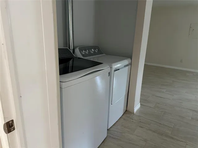 a utility room with wooden floor washer and dryer