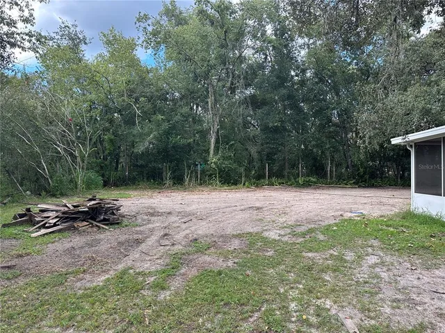 a backyard of a house with table and chairs