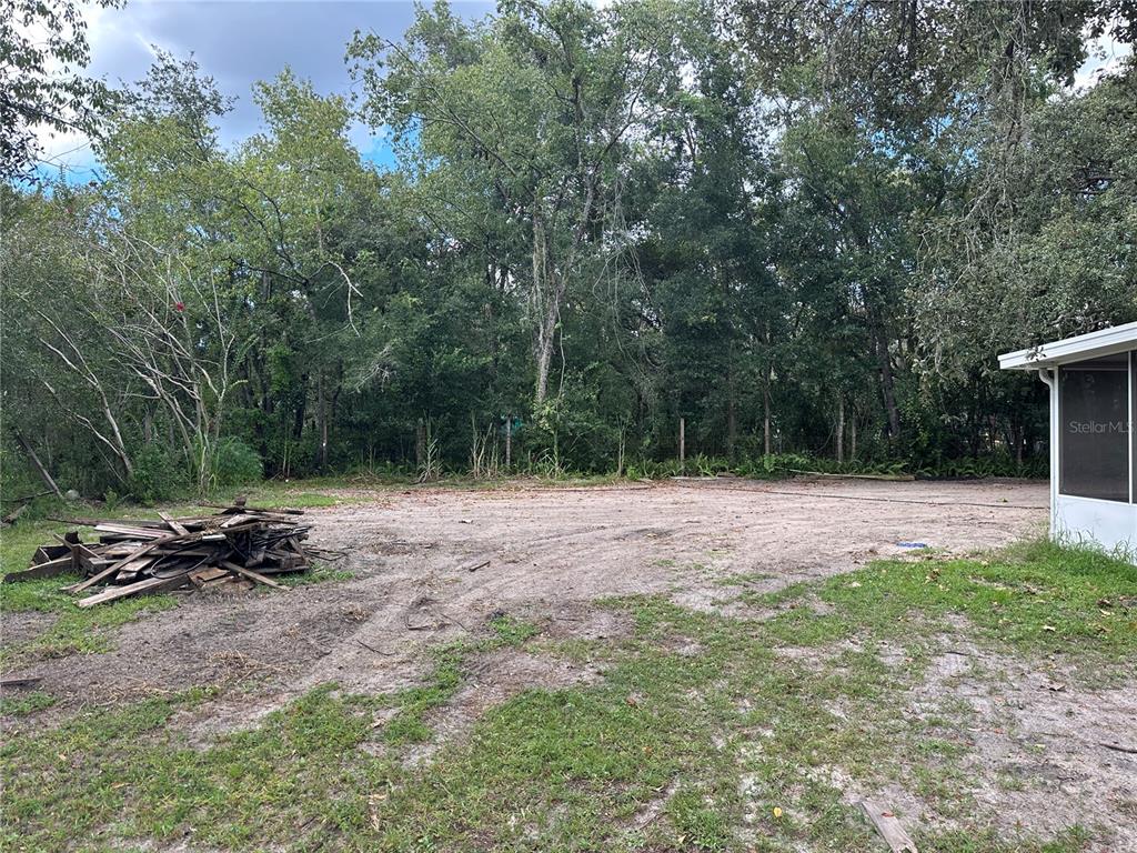15921 Breakwater Lane Spring Hill, FL 34610 - Photo 7 of 26 a backyard of a house with table and chairs
