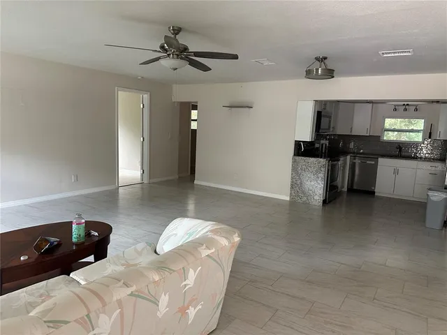 a living room with stainless steel appliances kitchen island granite countertop furniture and a kitchen view