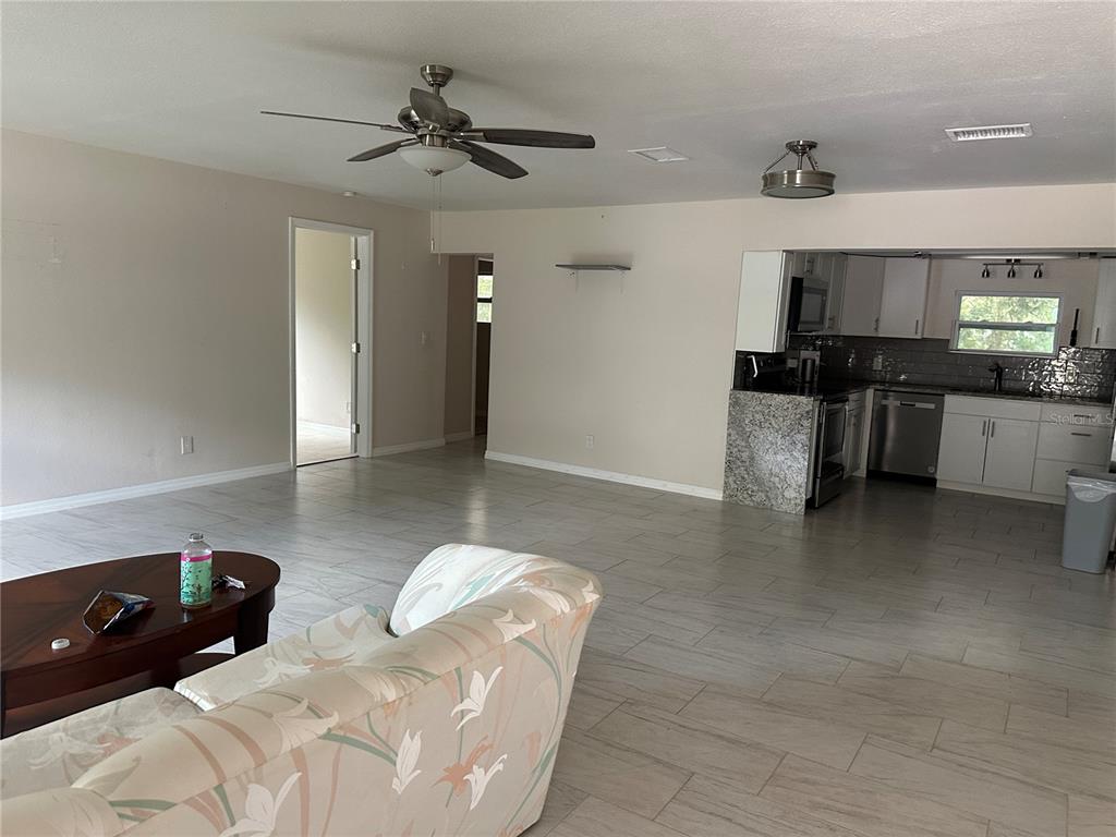 15921 Breakwater Lane Spring Hill, FL 34610 - Photo 10 of 26 a living room with stainless steel appliances kitchen island granite countertop furniture and a kitchen view