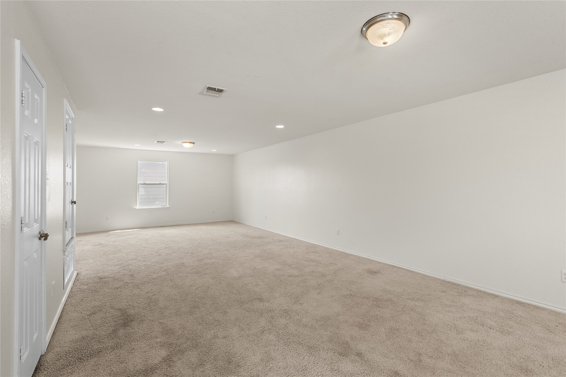 8613 Capitol View Drive Austin, TX 78747 - Photo 25 of 33 A spacious upstairs room featuring warm neutral carpet and several recessed ceiling lights.