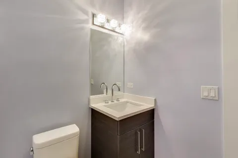 a bathroom with a sink vanity and a toilet