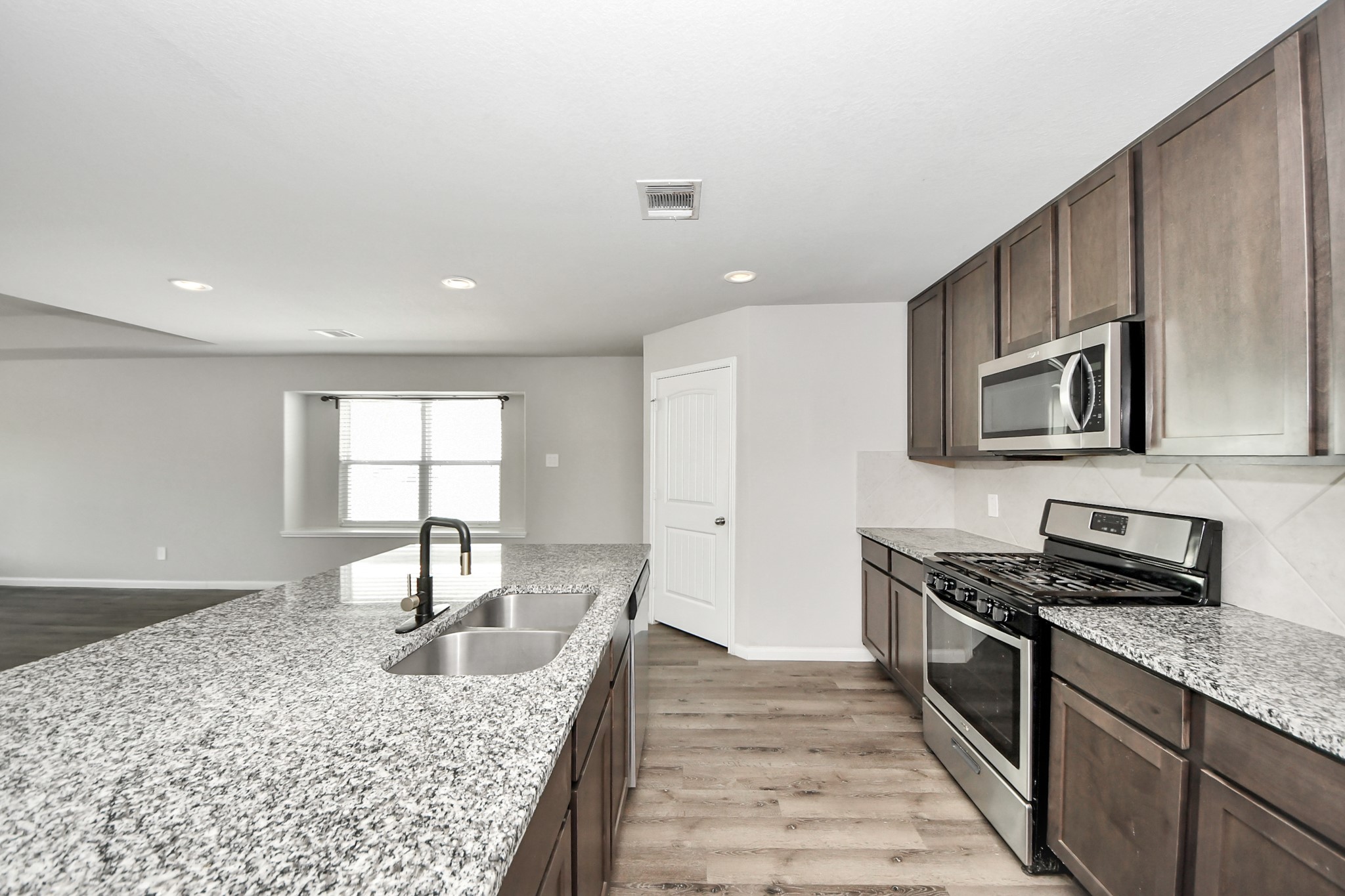 5626 Brooklyn Rose Drive Rosharon, TX 77583 - Photo 11 of 34 a kitchen with stainless steel appliances granite countertop a sink stove and microwave