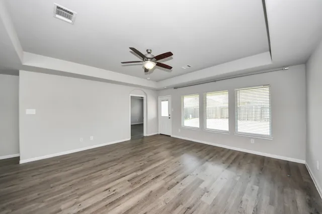 a view of a livingroom with a ceiling fan and wooden floor