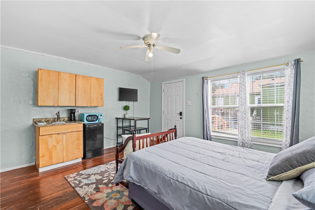 438 Indiana Avenue Corpus Christi, TX 78404 - Photo 7 of 8 a bedroom with a bed and a table in it with wooden floor