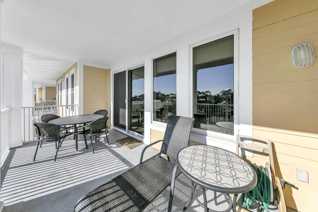a dining room with furniture a rug and a floor to ceiling window