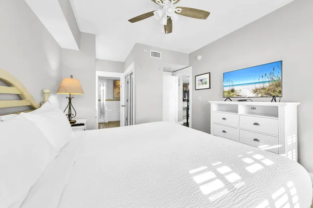 a bedroom with a large bed and a chandelier