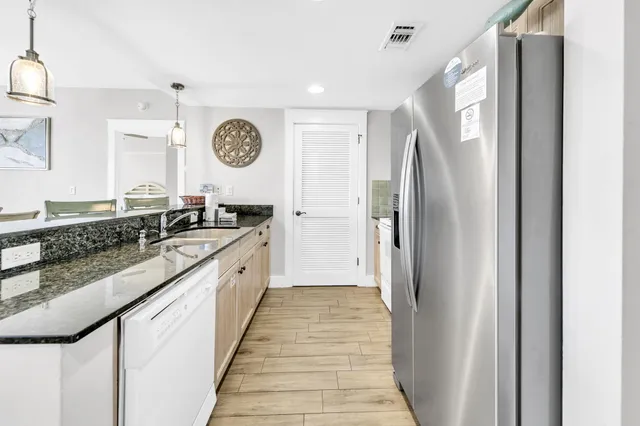 a large kitchen with a sink and a refrigerator