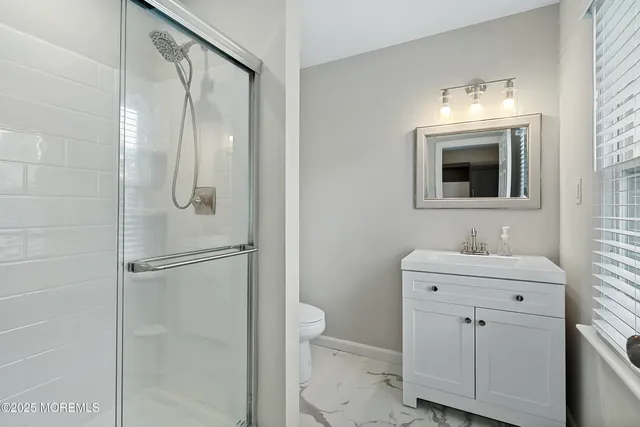 a bathroom with a sink a toilet and shower