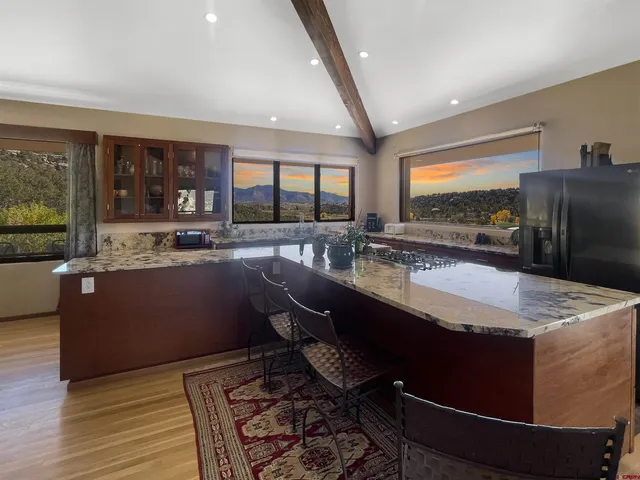 a kitchen with stainless steel appliances granite countertop a sink and a refrigerator