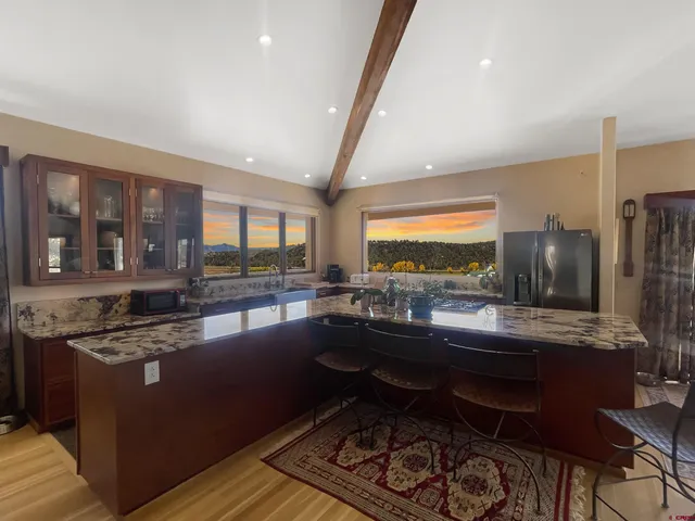 a kitchen with stainless steel appliances granite countertop sink stove and wooden cabinets
