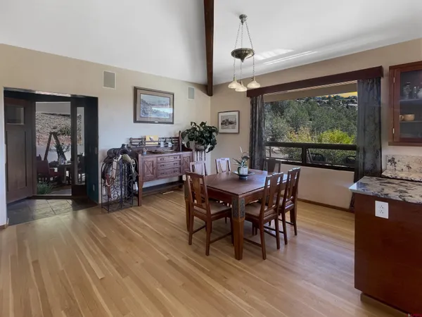 a dining room with furniture a large window and wooden floor