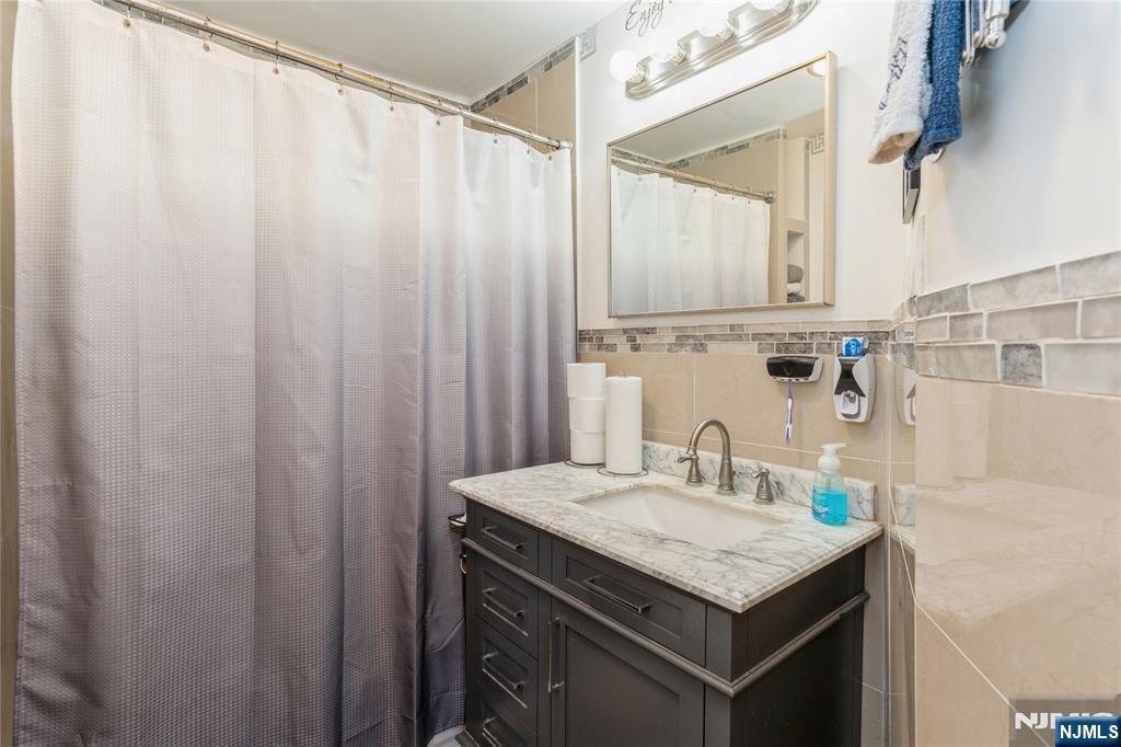 656 Scotland Road Orange, NJ 07050 - Photo 16 of 23 a bathroom with a granite countertop sink and a mirror
