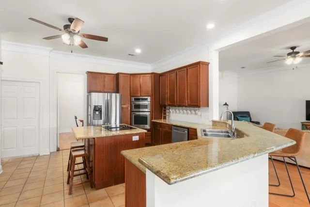 a kitchen with stainless steel appliances granite countertop a sink a stove and a refrigerator