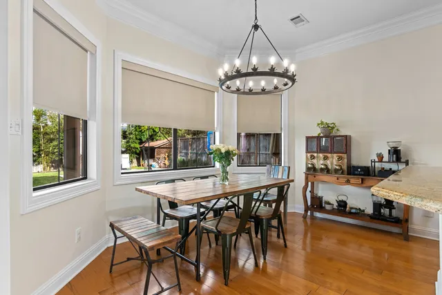 a view of a dining room with furniture a chandelier and wooden floor