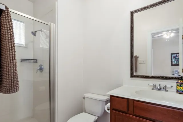 a bathroom with a granite countertop sink toilet and shower