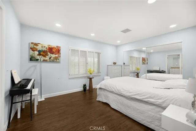 a spacious bedroom with a bed and a painting on the wall
