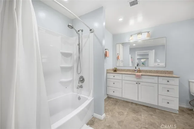 a bathroom with a granite countertop sink a bathtub a mirror a shower and vanity